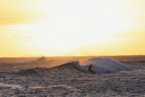 Surfers and sunset at Poipu Beach Park